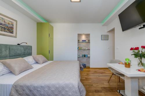 a bedroom with a bed and a desk and a television at Split centar Aria apartment in Split