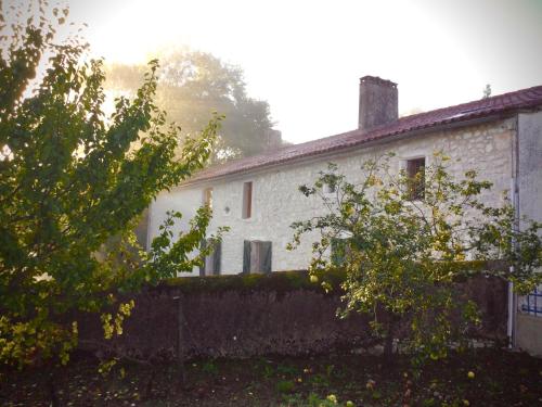 una casa blanca con una valla delante en Belle et spacieuse chambre d’hôtes avec piscine, en Savignac-de-Duras