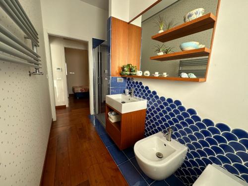 Appartamento Mira Capri في توري أنونزياتا: حمام من البلاط الأزرق مع مرحاض ومغسلة