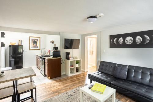 een woonkamer met een zwarte leren bank bij Spacious Guest Suite Amazing Location in San Diego