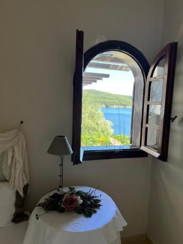 a room with a table and an open window at Kis-Kis in Metókhion Ayías Kiriakís