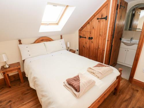 Schlafzimmer mit einem großen weißen Bett und einem Fenster in der Unterkunft The Mill and Stable in Llansadurnen