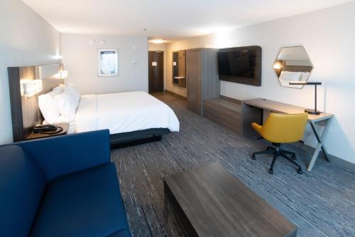 a hotel room with a bed and a desk and a television at Holiday Inn Express & Suites - Moose Jaw by IHG in Moose Jaw
