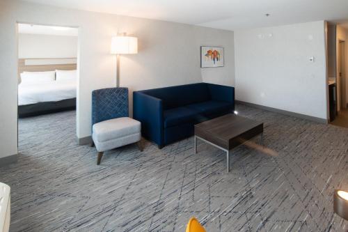 a hotel room with a couch and a chair and a bed at Holiday Inn Express & Suites - Moose Jaw by IHG in Moose Jaw