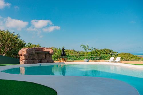 a swimming pool in a yard with a rock wall at Hotel Explore Caño Dulce in Tubará