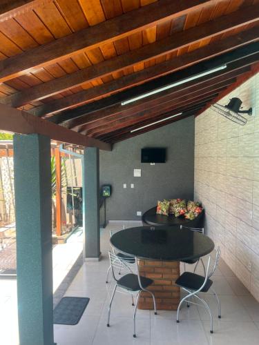 un patio avec une table et des chaises sous un plafond en bois dans l'établissement Residencia Canterville, à Olímpia