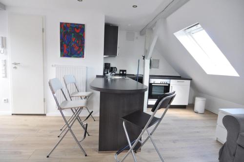 a kitchen with a counter and chairs in a room at Wertschätzer II - Unter der Wehme in Detmold