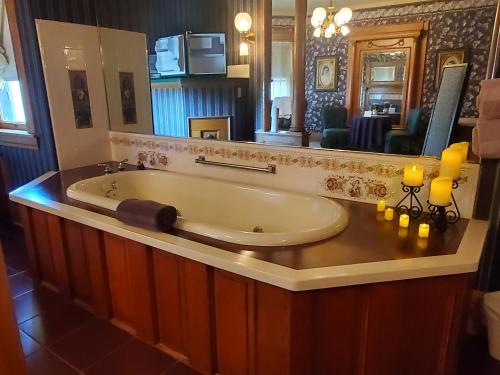 uma banheira na casa de banho com um espelho grande em The Weis Mansion Bed and Breakfast em Waterloo