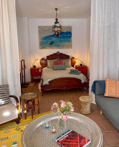 a bedroom with a bed and a table with flowers on it at Casa Amigos - La Viña in Sorvilán