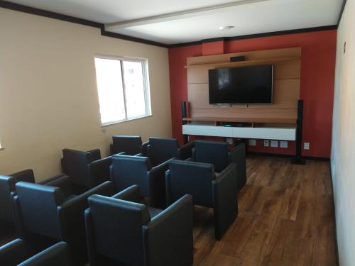 a room with chairs and a flat screen tv at Apartamento no Golden Lake - pé na areia, agua de côco e cervejinha in Arraial do Cabo