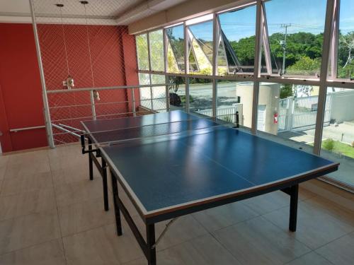 a ping pong table in the middle of a room at Apartamento no Golden Lake - pé na areia, agua de côco e cervejinha in Arraial do Cabo
