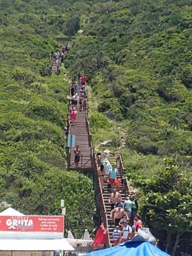 a group of people standing on a suspension bridge at Apartamento no Golden Lake - pé na areia, agua de côco e cervejinha in Arraial do Cabo
