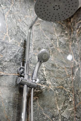 a shower head sitting on top of a rock at Сердце города 1комн ЖК Молодёжный in Almaty