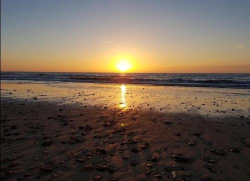 a sunset on a beach with the ocean at The Log Cabin in Wimborne Minster