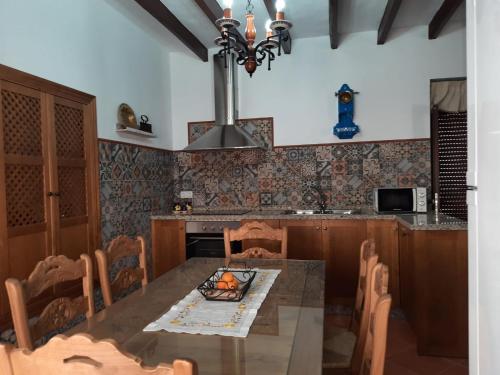 cocina con mesa de comedor y lámpara de araña en La Cata, en Aguilar de la Frontera