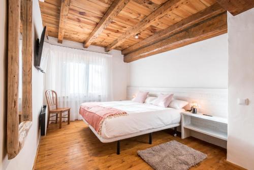 a bedroom with a bed and a wooden ceiling at Riu Nere - Pleta de Jus by Totiaran in Naut Aran
