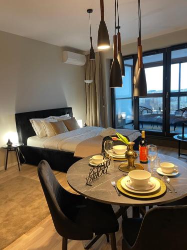 salon ze stołem i łóżkiem w obiekcie VISTULA TERRACES 10th floor w Krakowie