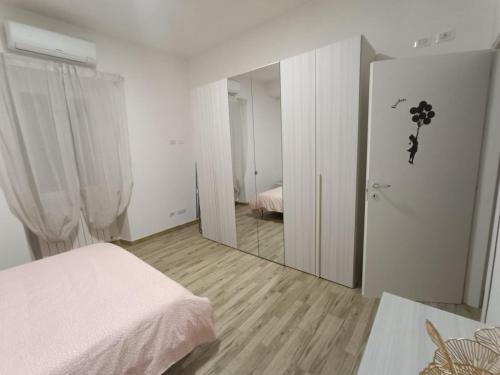 a white bedroom with a mirror and a bed at Casa No-Vi in Rome