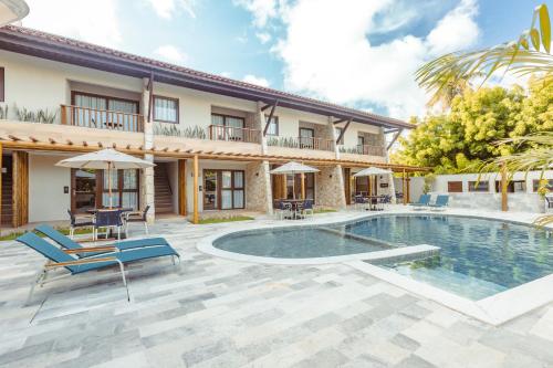 a villa with a swimming pool and patio furniture at MAIHAI Porto in Porto De Galinhas