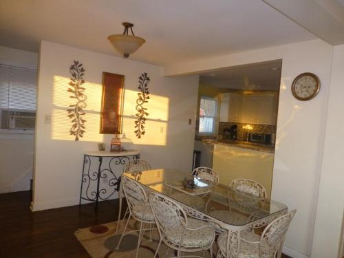 a dining room with a glass table and chairs at Red brick house in Chalfont