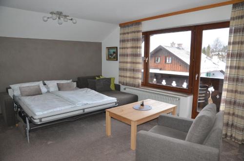 uma sala de estar com uma cama, um sofá e uma mesa em Ferienwohnung Steinhauser em Klais