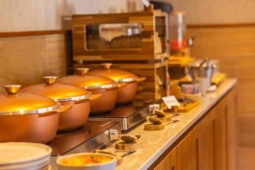 eine Reihe von Töpfen und Pfannen auf einer Theke in einer Küche in der Unterkunft MAIHAI Porto in Porto De Galinhas