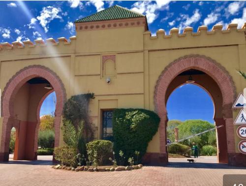 馬拉喀什的住宿－marrakech palmeraie village Etablissement jasmin，前面有两座拱门的建筑