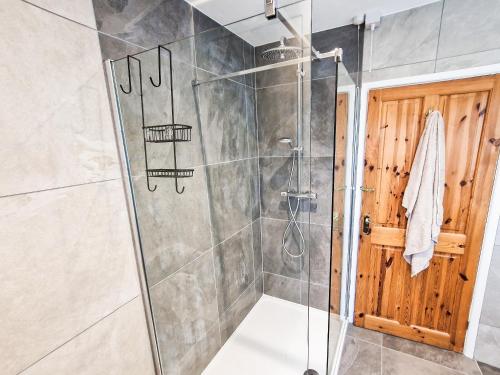 um chuveiro com uma porta de vidro na casa de banho em Sea View Lodge em Rousdon