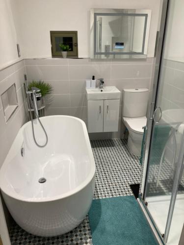 La salle de bains est pourvue d'une baignoire blanche et de toilettes. dans l'établissement Coiners Rest, à Heptonstall