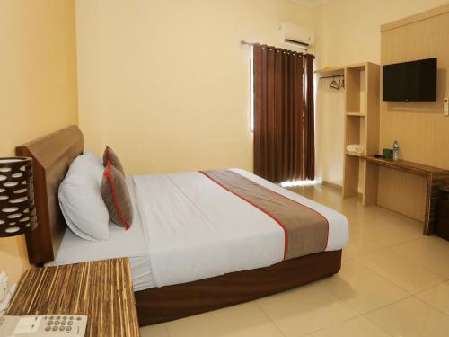 una camera d'albergo con letto e TV di SUPER OYO Collection O 92130 Hotel Fiducia Kaji a Giacarta