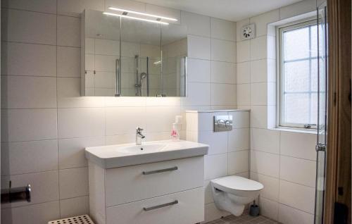a bathroom with a sink and a toilet and a mirror at Beautiful Home In Ronneby With Sauna in Ronneby