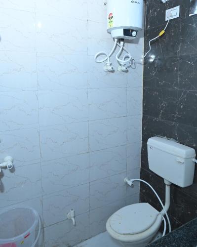a bathroom with a toilet and a water tank at Hotel Mukund Dham-Near Mathura Railway Station in Mathura