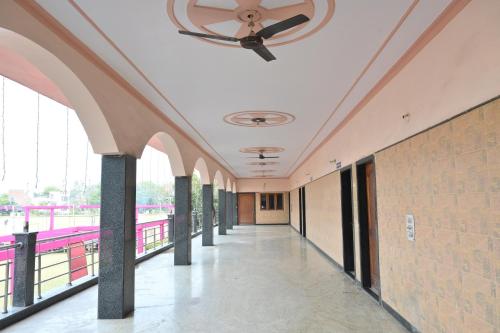 a hallway in a building with a ceiling fan at Hotel Mukund Dham-Near Mathura Railway Station in Mathura
