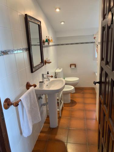 y baño con 2 aseos, lavamanos y espejo. en Apartament Cal Negre en Vilassar de Mar