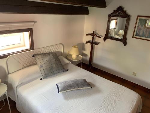 una camera da letto con un letto bianco con una croce sul muro di Apartament Cal Negre a Vilassar de Mar