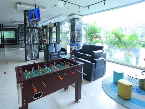 een woonkamer met een tafelvoetbaltafel en een bank bij Super OYO Townhouse OAK Hotel Fiducia Pondok Gede in Jakarta