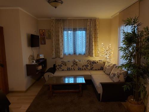 uma sala de estar com um sofá e uma mesa em Kuca za uzivanje em Valjevo