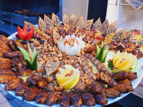 a platter of food with meat and flowers on it at شقة سيلا in Irbid