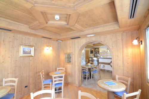 a room with wooden walls and tables and chairs at Albergo Alpenrose in Livigno