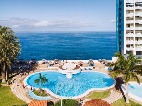una vista aérea de una piscina con el océano en el fondo en Precise Resort Tenerife en Puerto de la Cruz