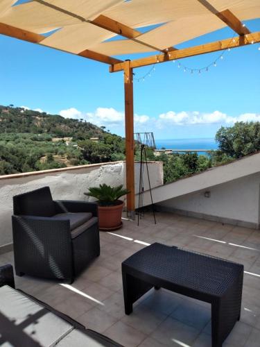 a patio with a chair and a table and an umbrella at Holiday Apartment Villa Camilla in Cefalù