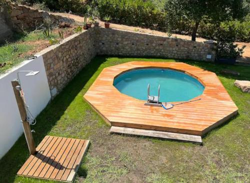 a wooden deck around a swimming pool with a clock in it at Holiday Apartment Villa Camilla in Cefalù