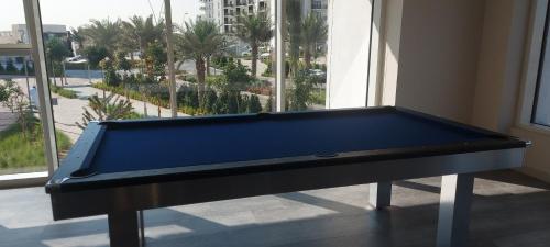 a blue pool table in a room with a window at Deluxe Apartment on YAS with Sea View Balcony in Abu Dhabi