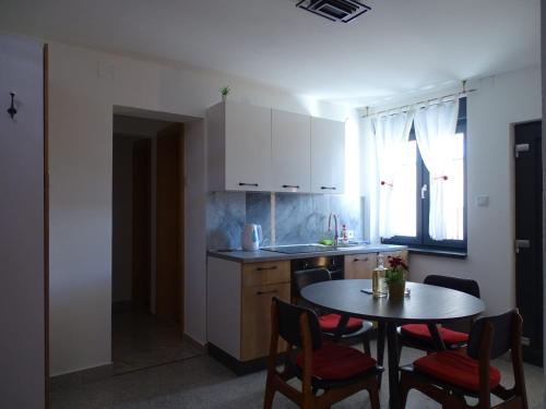 a kitchen with a table and chairs and a table and a dining room at Apartman Dabrović in Novska