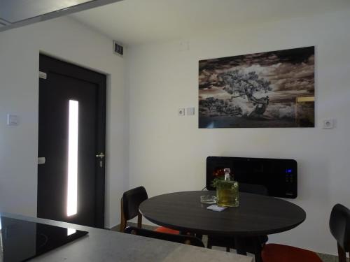 tavolo e sedie in una stanza con porta nera di Apartman Dabrović a Novska