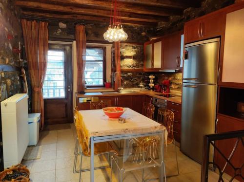 cocina con mesa y nevera de acero inoxidable en Luxury Residence Jenny, en Palaios Agios Athanasios