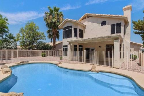 uma casa com piscina em frente a uma casa em Desert LUXURY! 6 bdrm, 3 bath & HEATED pool (SLEEPS 16) em Chandler