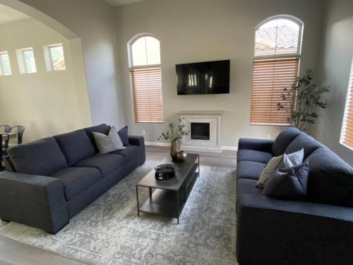 uma sala de estar com um sofá azul e uma mesa em Desert LUXURY! 6 bdrm, 3 bath & HEATED pool (SLEEPS 16) em Chandler
