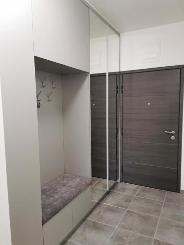 a walk in closet with white walls and glass doors at Alex LUX in Banja Luka