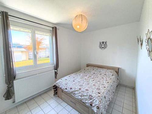 een kleine slaapkamer met een bed en een raam bij Maison avec extérieur et arrivée autonome - Aurillac in Aurillac